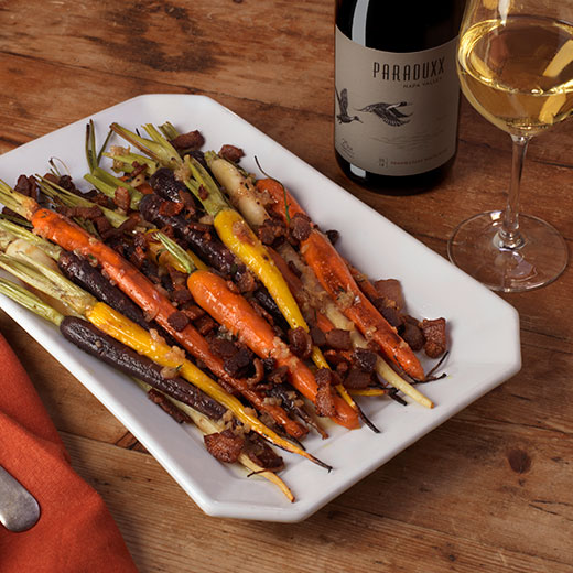 Roasted rainbow carrots with a glass of Paraduxx white wine blend